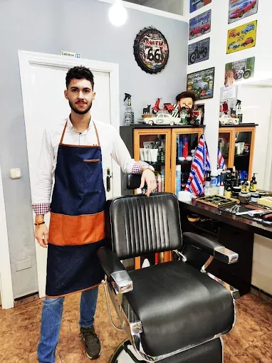 Profesional con delantal junto al sillón de La Barbería de José Alejandro en Lorca