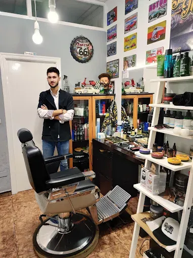 Retrato junto al puesto de trabajo y los espejos de La Barbería de José Alejandro