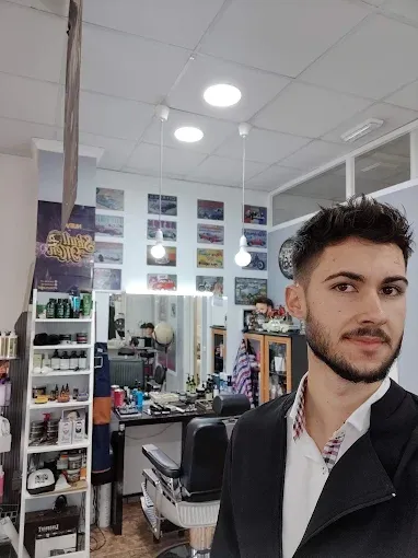 Retrato en el local con los espejos y la decoración de la barbería al fondo