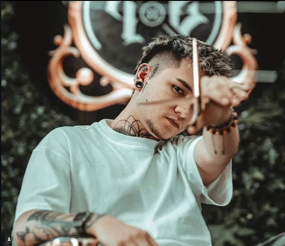 Profesional de The Lords Barber con sus tijeras en la barbería